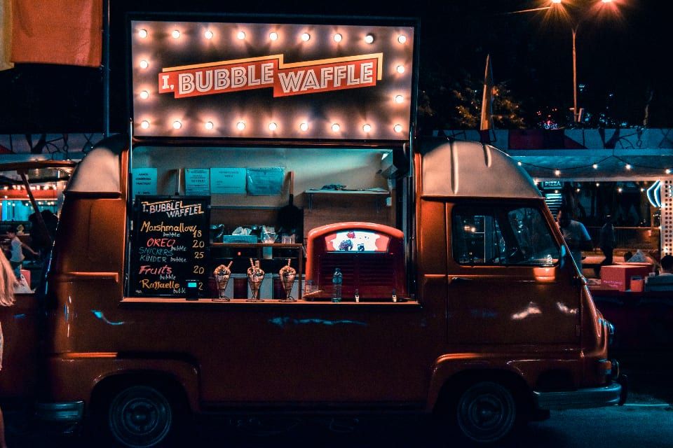 A lit-up food truck serving at night